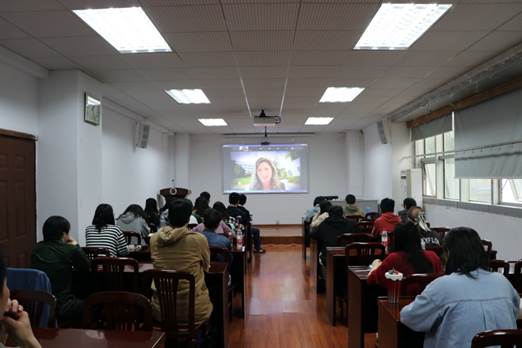 A group of people sitting in a room watching a presentationDescription automatically generated with low confidence
